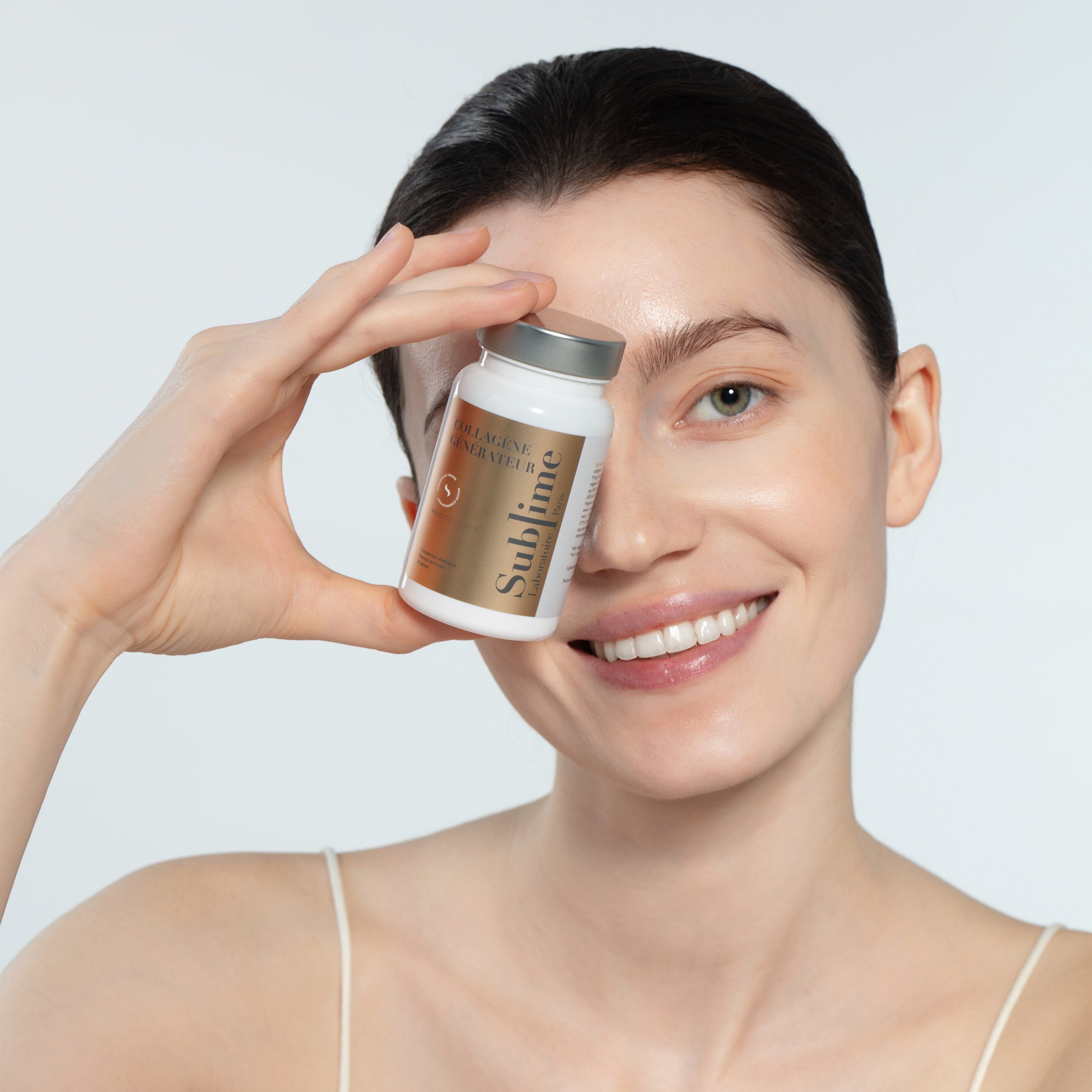 Woman holding Laboratoire Sublime Rejuva Collagen supplement bottle, collagen beauty supplement for radiant skin, front portrait view.