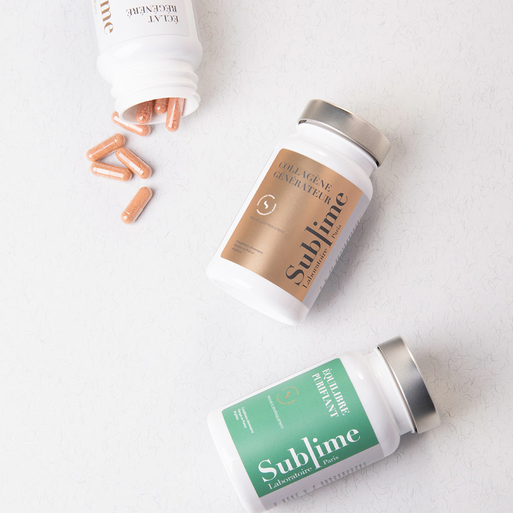 Laboratoire Sublime Rejuva Collagen and Purifying Balance supplement bottles with capsules spilled on a white surface, elegant minimalist flat lay for French beauty nutrition