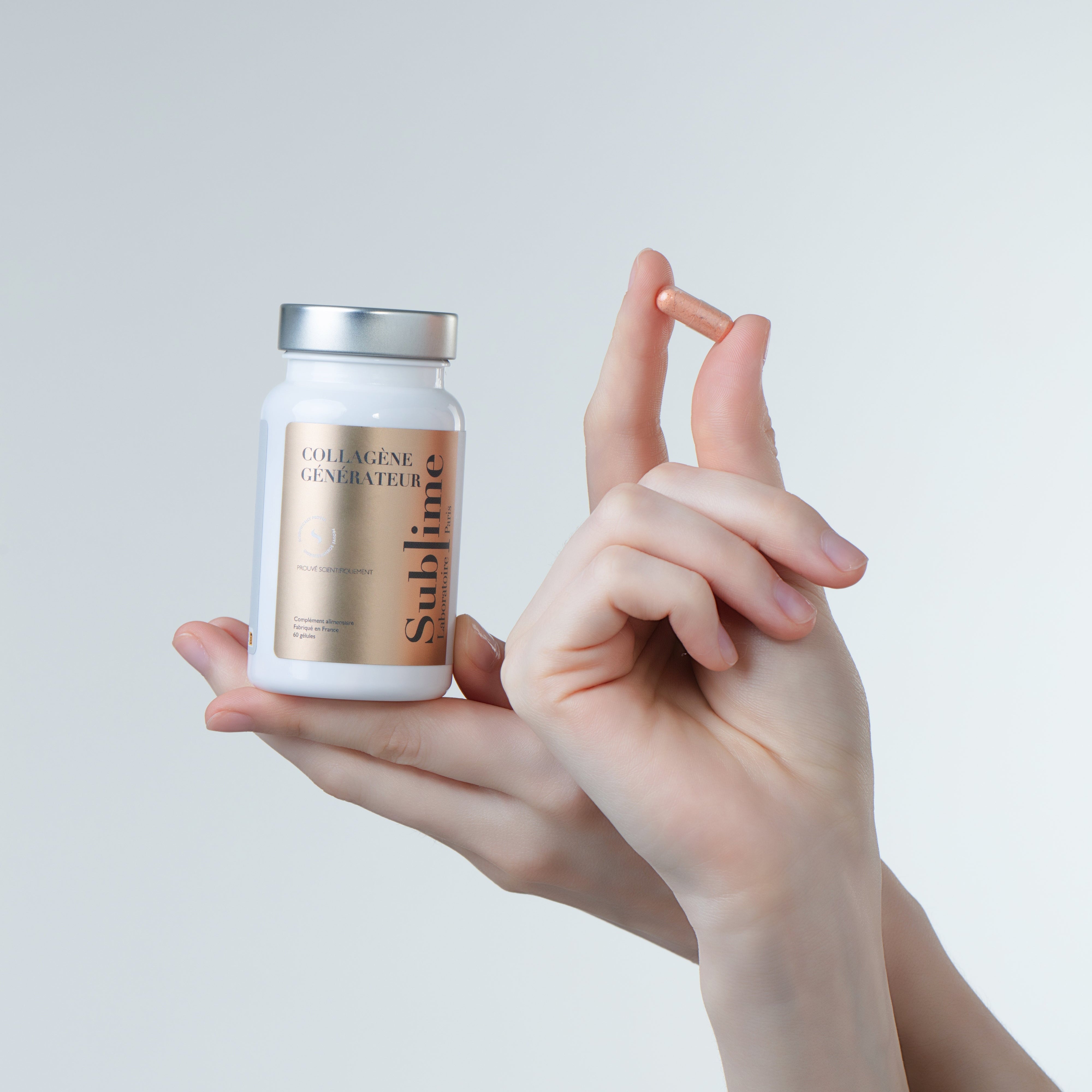Hand holding Laboratoire Sublime Rejuva Collagen supplement bottle and capsule, French collagen beauty supplement for skin firmness, front view on gray background.